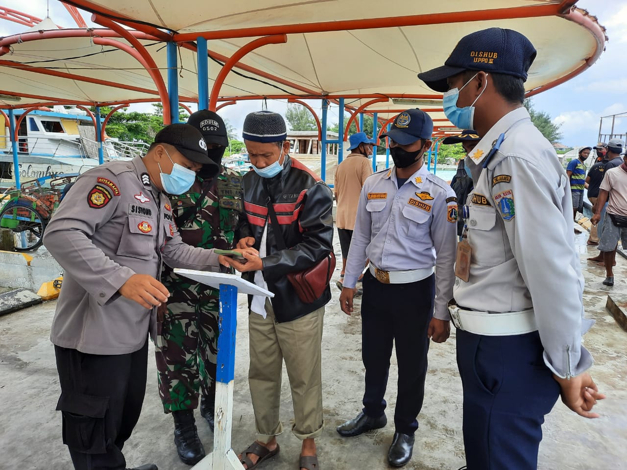 Di Dermaga Kedatangan, Polsek Kep Seribu Utara Pandu Warga Scan Barkode Aplikasi Peduli Lindungi